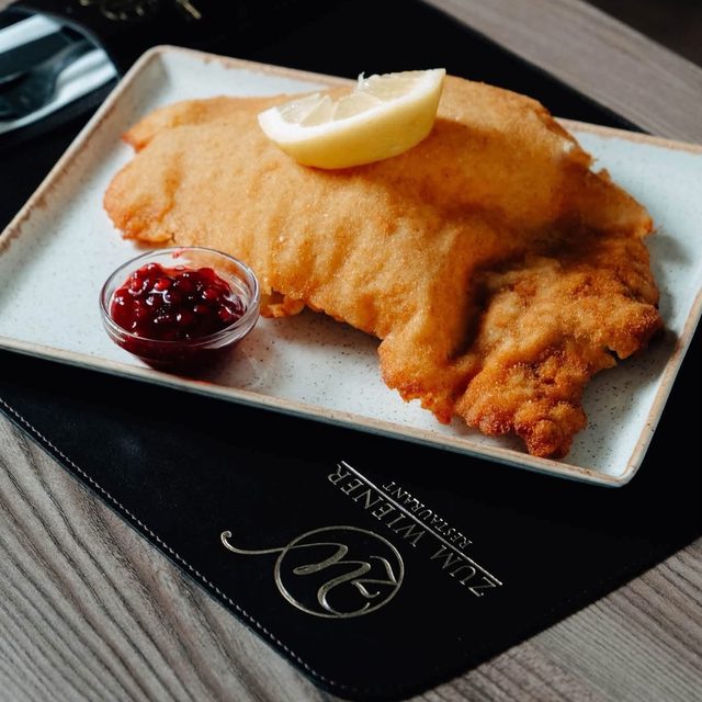 Knusprig. Goldbraun. Einfach Wiener. Unser Original Wiener Schnitzel: hauchdünn geklopft, goldbraun ausgebacken, mit Zitrone und Preiselbeeren serviert.